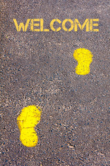 Yellow footsteps on sidewalk towards Welcome message