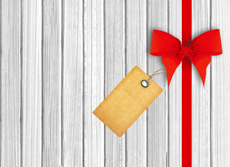 white wooden background with beautiful red bow and tag