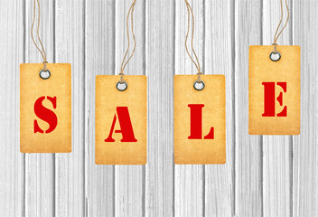 Sale tags over white wooden background
