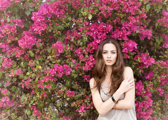 Naklejka premium portrait of a beautiful brunette girl in summer colors flowers