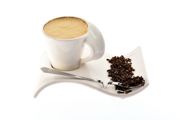 Cup of coffee with milk on stand grain seeds and spices