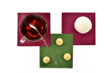 Cup of black tea with a spoonful marshmallows on napkins