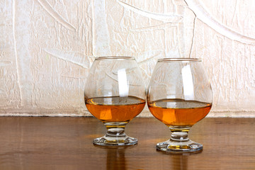 Two goblets of brandy on wooden old counter top