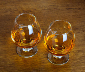Two goblets of brandy on wooden old counter top