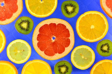 Fototapeta na wymiar Background of different kinds citrus fruits and kiwis