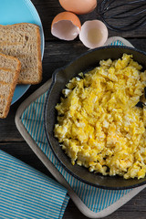 scrambled eggs in vintage frying iron pan, overhead view
