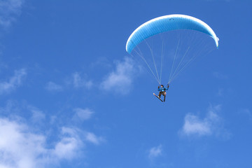 Paragliding in the blue sky with skis