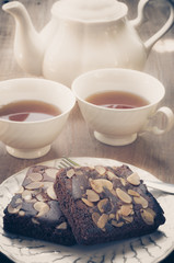Sweet beownie and cup of tea on wooden table