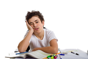 Tired boy holds his face in front of homework