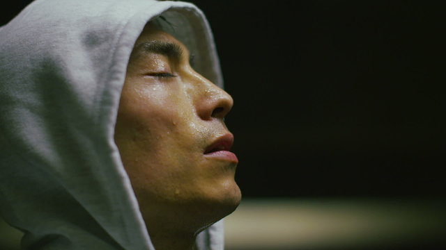 Hooded athlete getting his breath back
