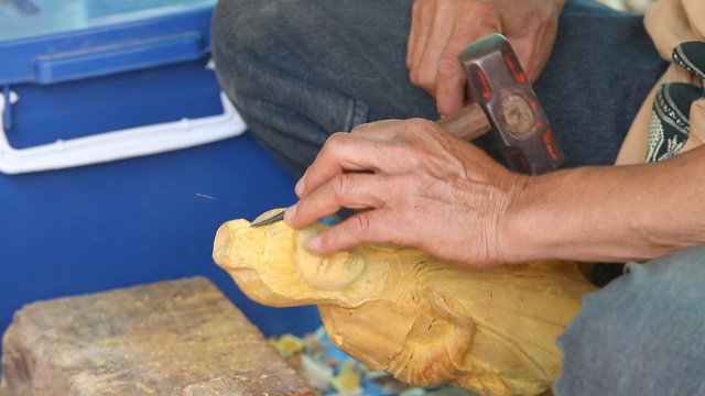 Hand of carver carving wood