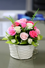 Artificial roses in a vase of flowers.