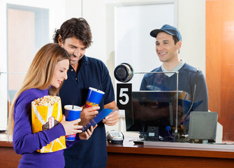 Couple Buying Movie Tickets At Box Office © Tyler Olson