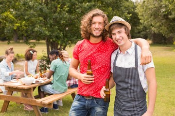 Happy friends in the park having barbecue