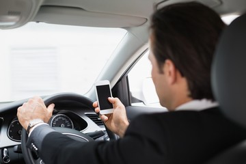 Businessman sending a text message