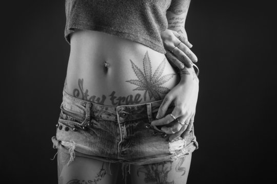 Close up of beautiful woman with tattoo wearing jeans short pain
