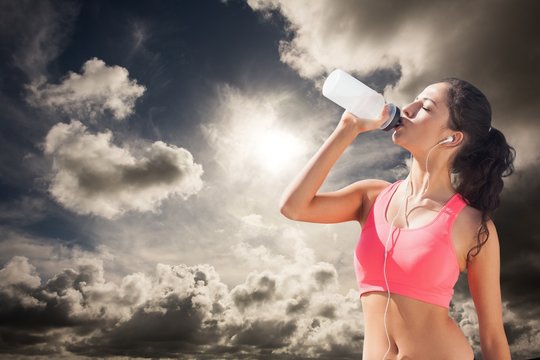 Composite image of beautiful healthy woman drinking water
