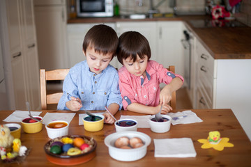 Fototapeta premium Two boys, coloring eggs for Easter