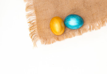 golden and blue eggs with sacking on white background