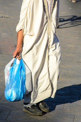 Mann mit Kaftan tr&auml;gt Eink&auml;ufe &uuml;ber Markt