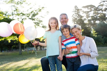 Happy family holding balloons at the park