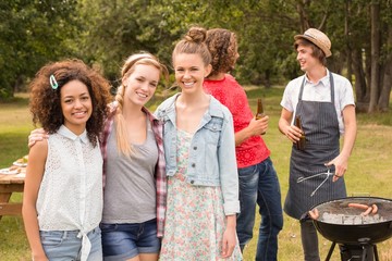 Happy friends in the park having barbecue