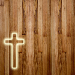 Glowing holy cross on abstract wooden background