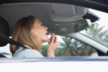Young woman putting on makeup