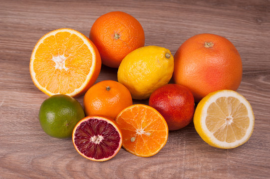 different citrus fruits on wooden background