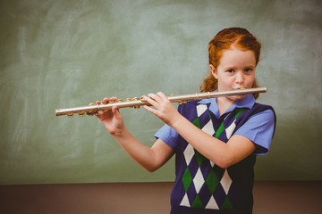 Cute little girl playing flute in classroom © WavebreakmediaMicro