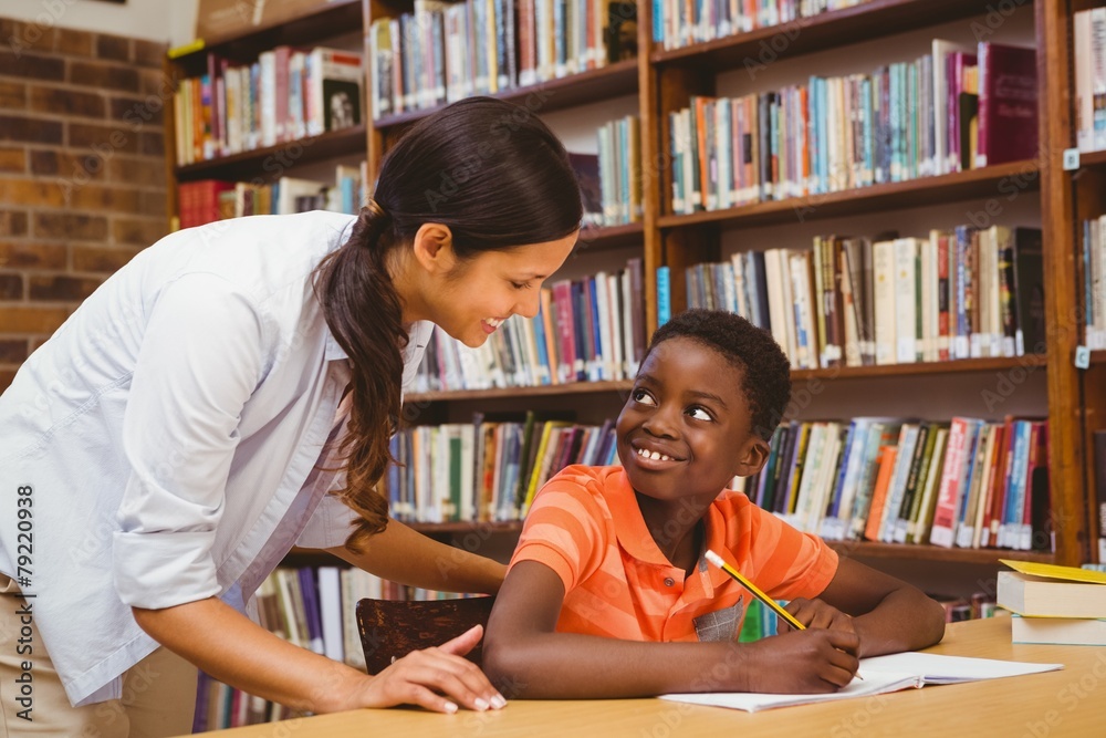 Poster teacher assisting boy with homework in library