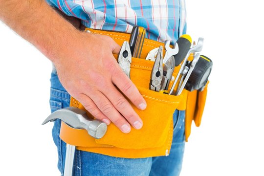 Midsection of handyman wearing tool belt