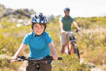 Father and son biking through mountains