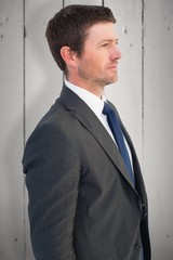 Composite image of handsome businessman looking away