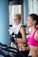 Fototapeta premium friends exercising on a treadmill at the bright modern gym