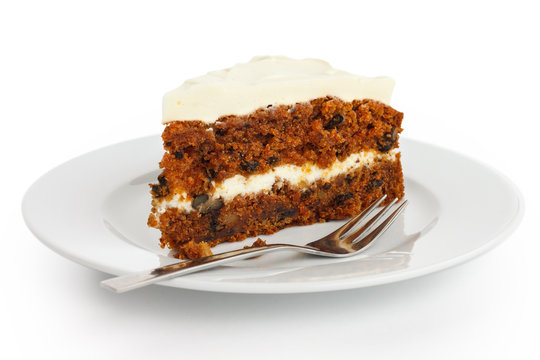 Slice of carrot cake with rich frosting. On plate.