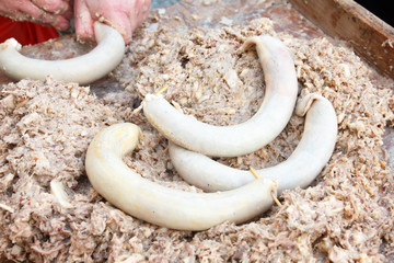 Czech liver sausages being stuffed into casings by hand.