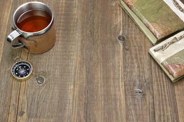 Compass, Tea Mug and Two Notebooks on Wood Table