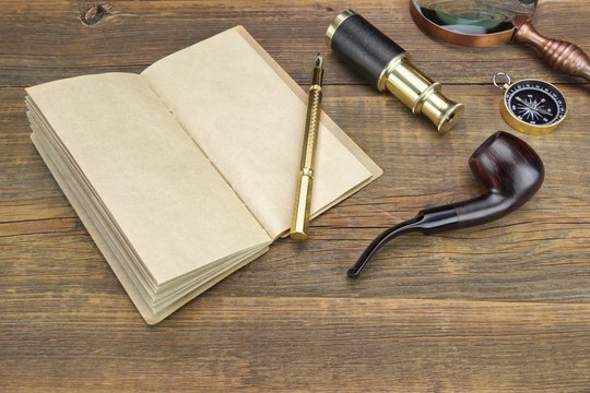 Notebook, Pen, Magnifier, Cpmpass, Pipe, Spyglass On Wood Backgr