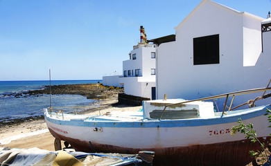 Fototapeta na wymiar Barca junto a una casa en Arrecife, Lanzarote