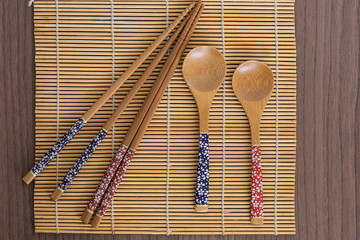 Bamboo sushi tools over a bamboo mat