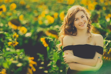 Naklejka na ściany i meble beautiful girl in black dres, field of sunflowers
