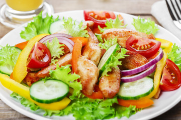 Salad with grilled chicken fillet tomatoes peppers and cucumber