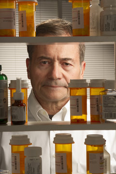 white male looking at assortment of prescription drugs