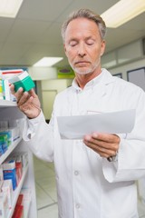 Pharmacist reading prescription and holding medicine