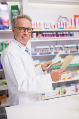 Smiling senior pharmacist holding prescription
