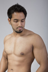 Fototapeta premium Young and fit male model showing his muscles