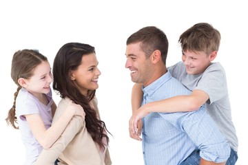 Happy parents giving piggyback ride to children