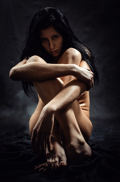 The naked woman on a black background