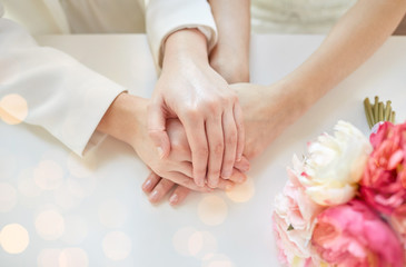 close up of happy married lesbian couple hands